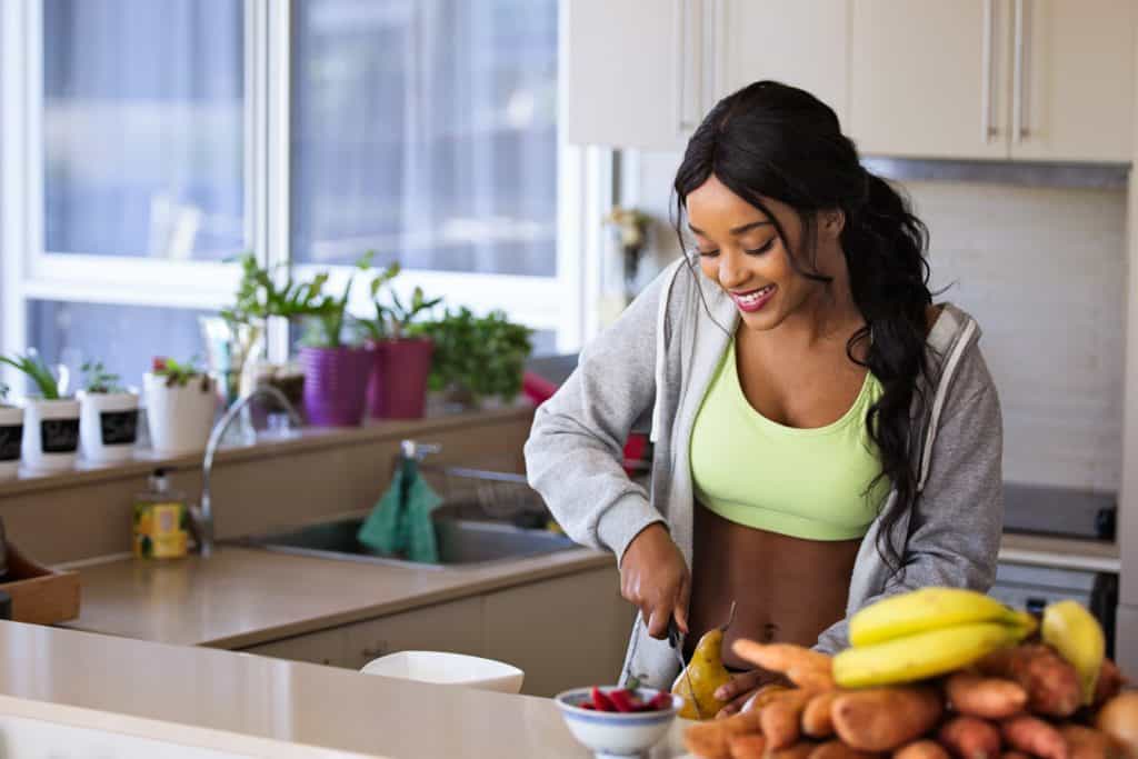 A woman cutting fruit after finding out why healthy eating is important